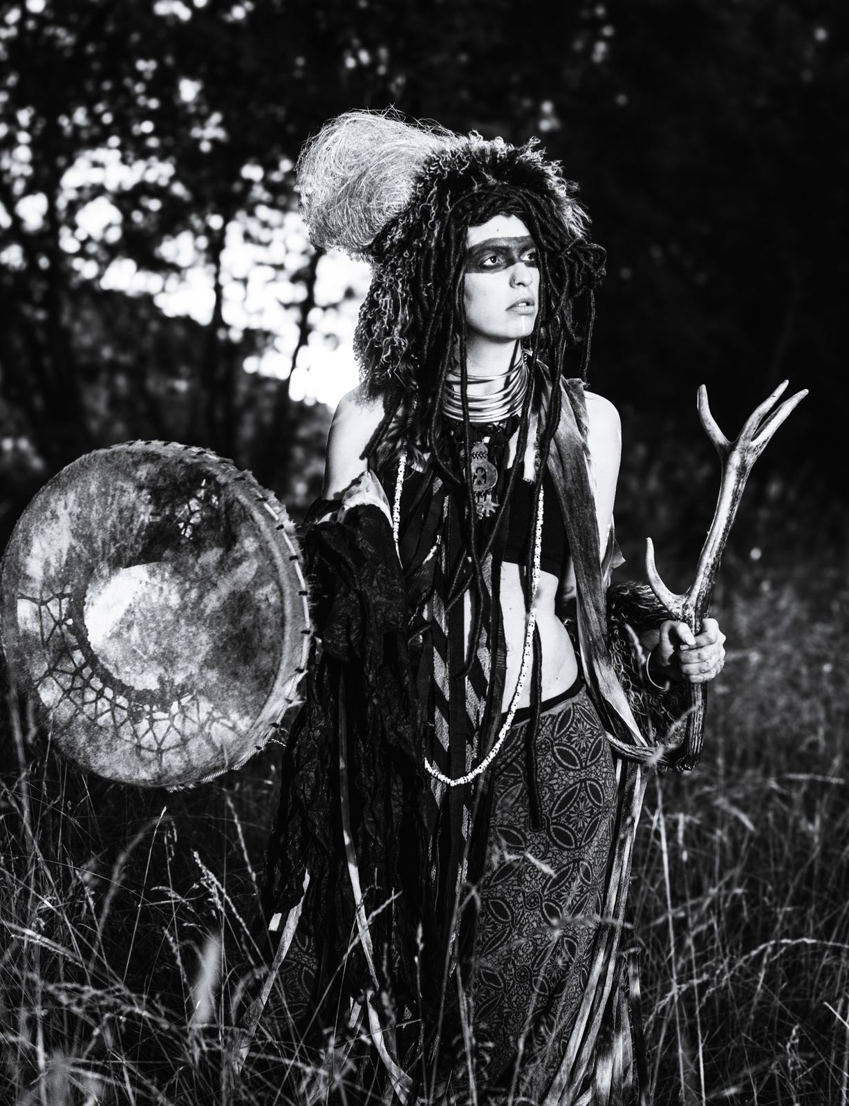 Shamanic portrait with drum and antler in the forest