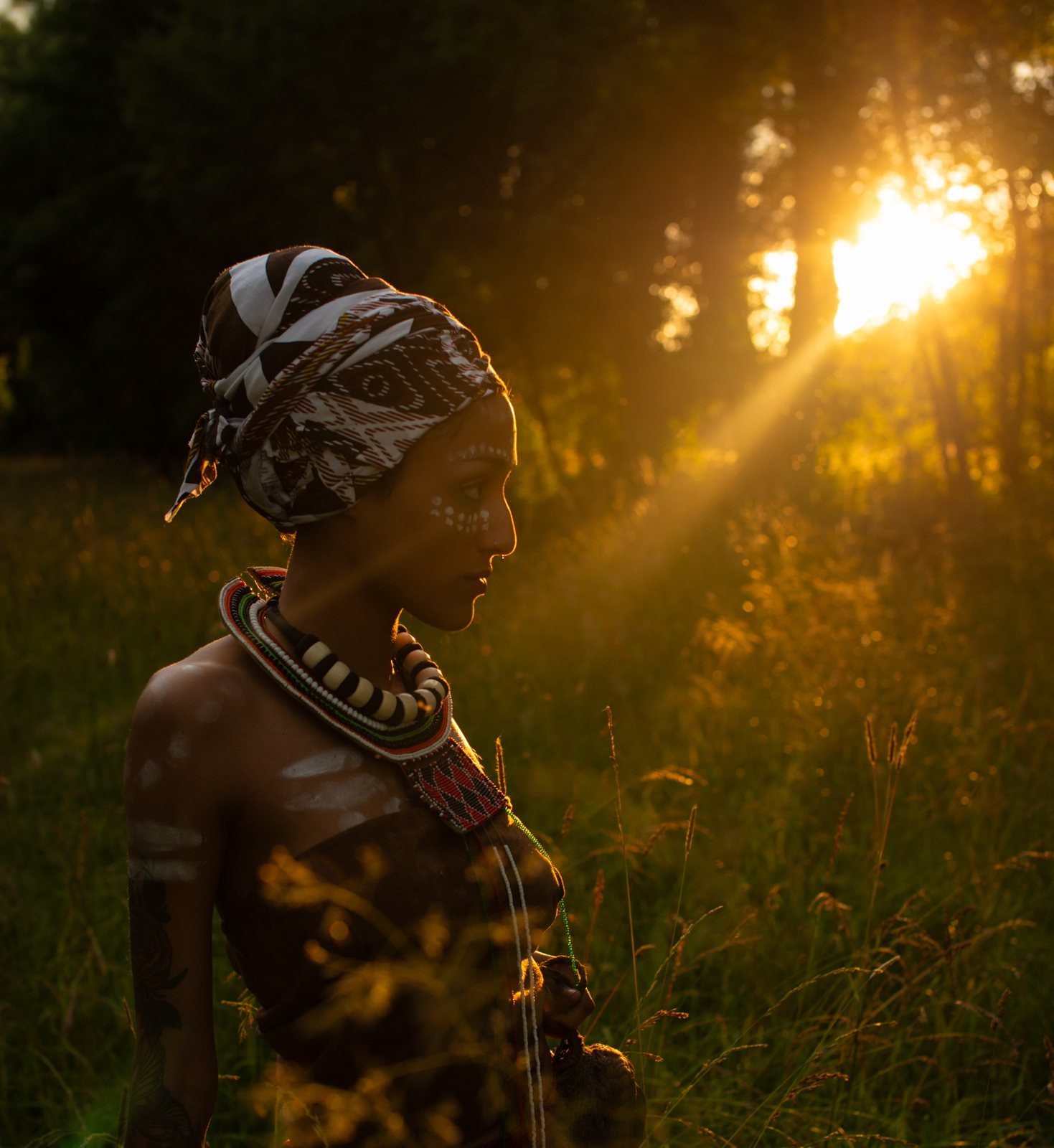 Profile with white face paint and headwrap in a sunbeam